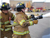 Two Firefighters handing a spraying fire hose