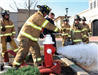 Firemen opening red fire hydrant with water gushing out