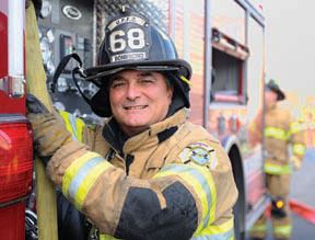Smiling fireman beside side of truck