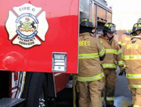 Open door of fire truck with firemen beside side of truck