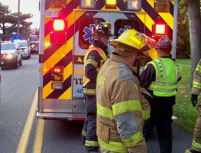Firemen loading person into ambulance