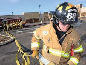 Firemen dragging firehose