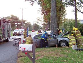 Firemen at the scene of an accident- car in tree
