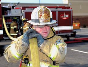 Fireman carrying fire hose over shoulder