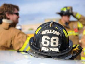 View of fireman's helmet with two firemen in back